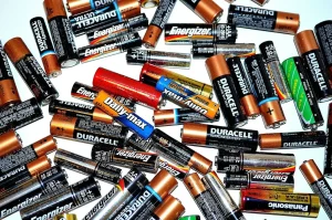 Discarded AA and AAA household batteries from brands like Duracell, Energizer, and Panasonic ready for eco-friendly disposal