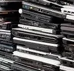Heavy piles of obsolete corporate laptops and notebook computers stacked for certified data destruction
