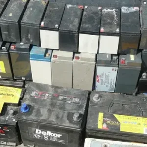 Decommissioned industrial lead acid batteries and backup power modules stacked for chemical extraction loops