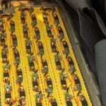 Large EV battery scrap cells with a green e-waste recycling logo for hazardous disposal.